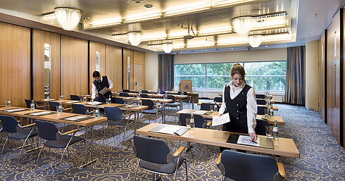 Saal Maritim II classroom style Staff preparing a conference room at Maritim Hotel Frankfurt with row seating and views of greenery.