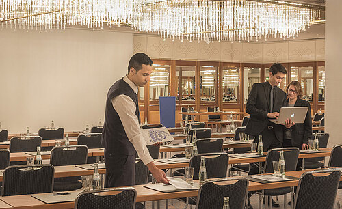 Maritim Conference Service Staff preparing meeting room with chandeliers at the Maritim Hotel Munich