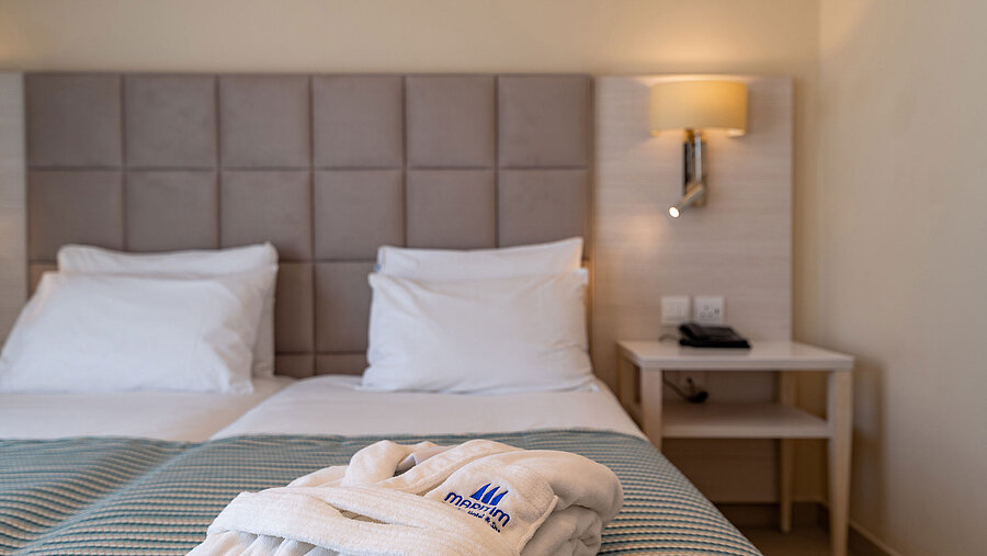 Deluxe Double room Close-up of a hotel bed with bathrobe and soft bedding