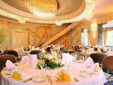 Fürst-von-Pückler-Saal Elegant banquet hall with wall paintings, chandeliers and festively set tables