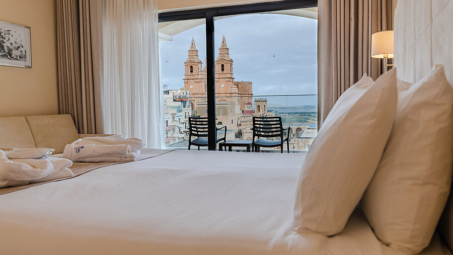 Deluxe Family Suite Hotel room with double bed, balcony and views of historic church and city