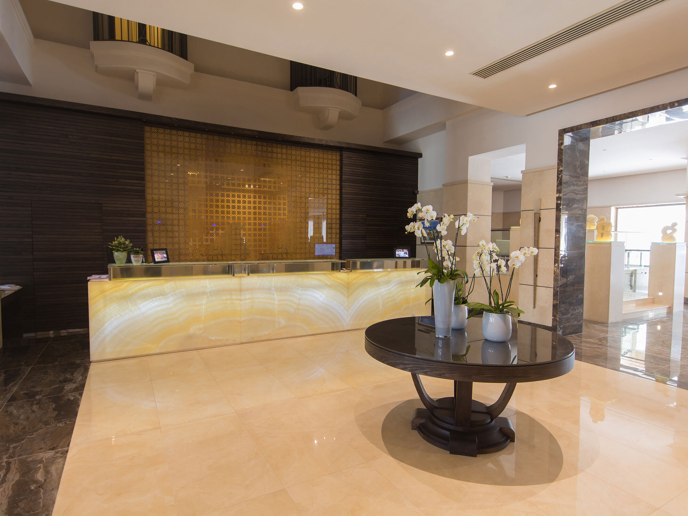 Reception Modern hotel reception with illuminated desk, orchids and elegant design