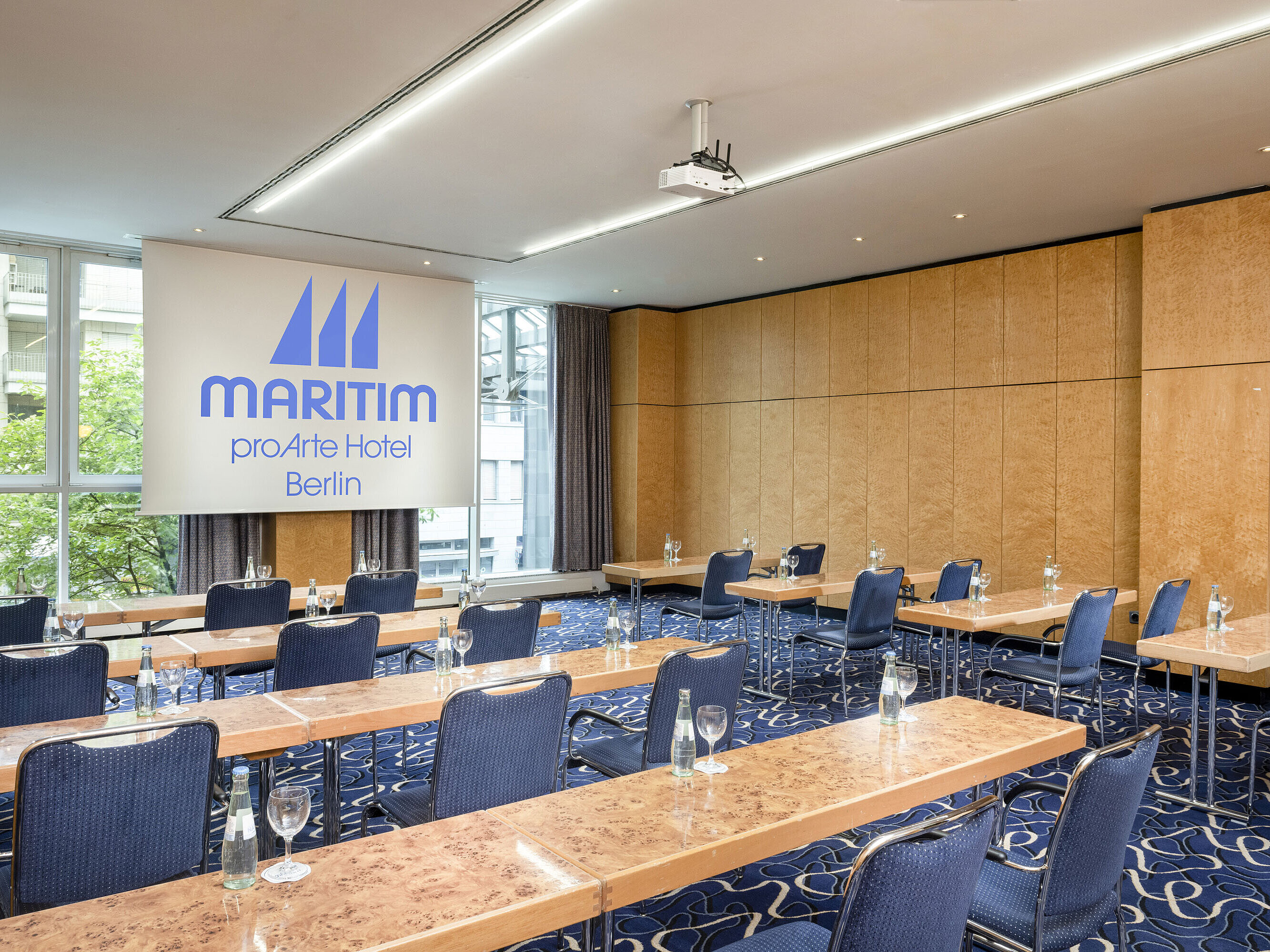 Salon 7 Conference room at Maritim proArte Hotel Berlin with row seating and projection screen.