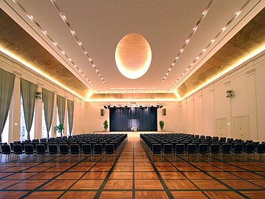 Ballroom Elegant banquet hall at Maritim Hotel Fulda with a stage, stylish lighting, and seating for events.
