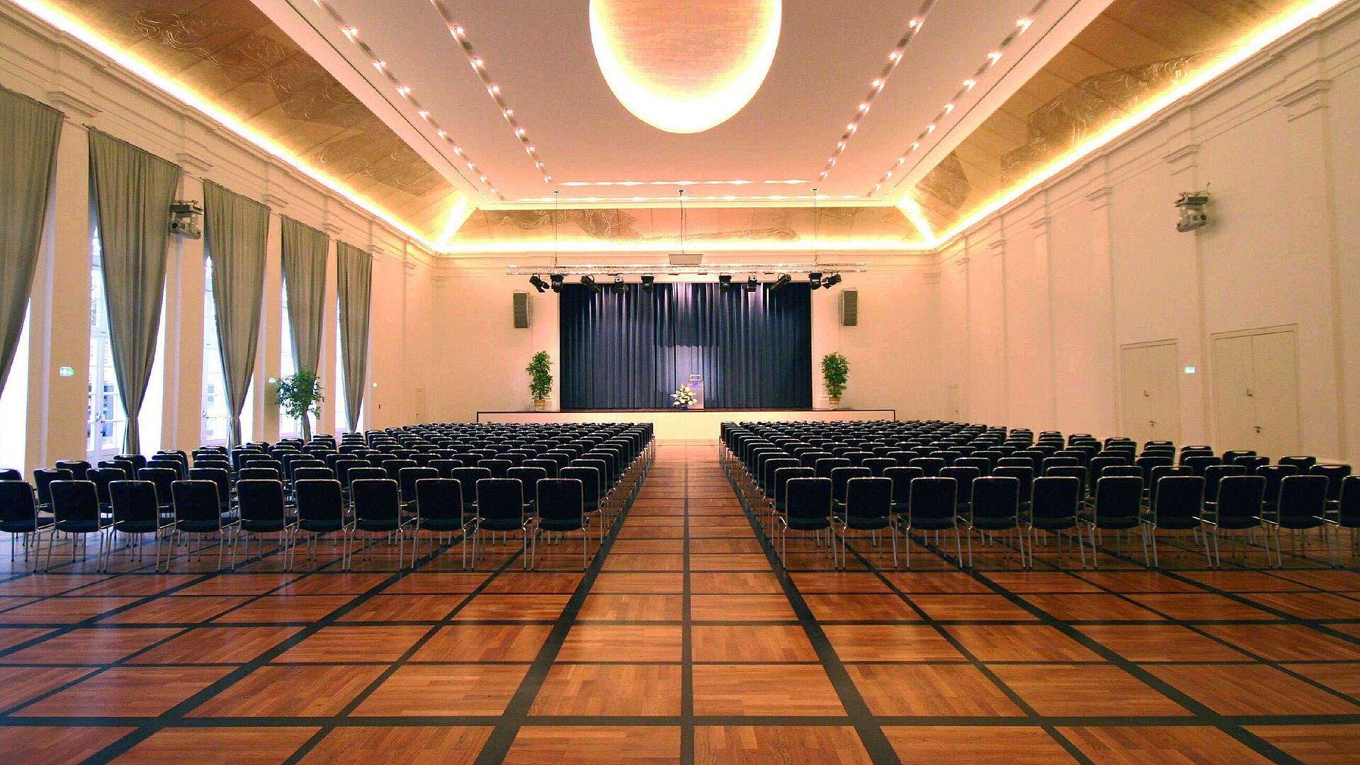 Ballroom Elegant banquet hall at Maritim Hotel Fulda with a stage, stylish lighting, and seating for events.