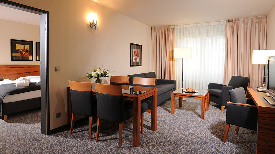 Senior suite Spacious suite with living room, dining table and separate bedroom at Maritim Hotel Munich