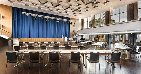 Saal Maritim Grand Hall "Maritim" at Maritim Seehotel Timmendorfer Strand with stage, blue curtains, and conference seating.