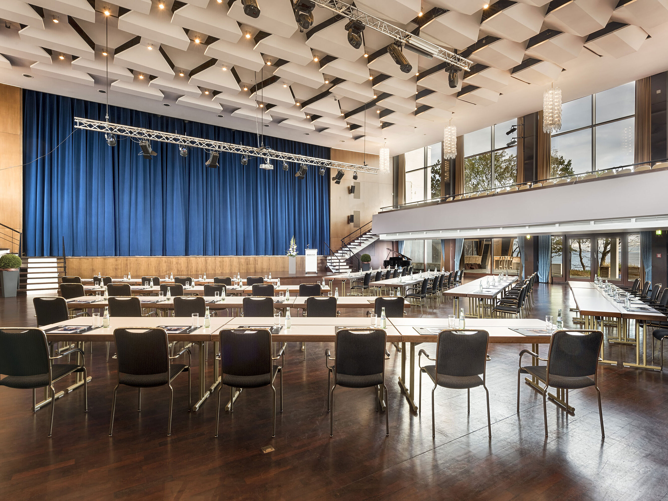 Saal Maritim Grand Hall "Maritim" at Maritim Seehotel Timmendorfer Strand with stage, blue curtains, and conference seating.
