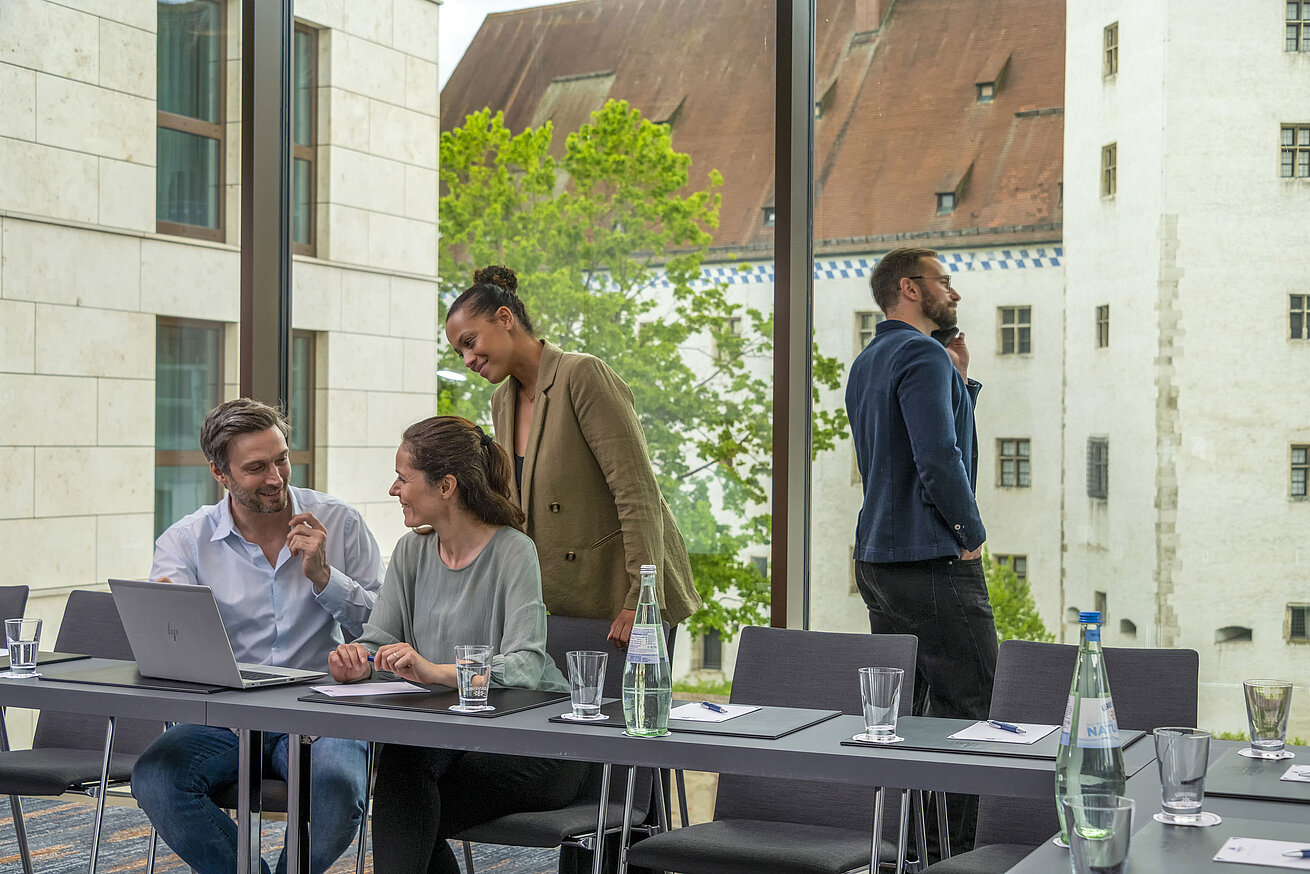 Meeting room Smiling business people in the meeting room at Maritim Hotel Ingolstadt with a view of historic buildings.