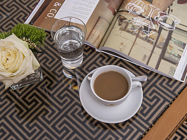 Detail of the hotel room Close-up with rose, coffee, water and magazine on glass table at the Maritim Hotel Stuttgart