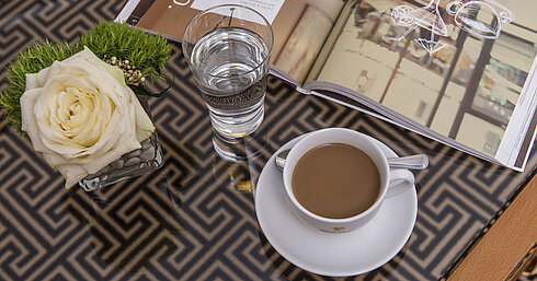 Detail of the hotel room Close-up with rose, coffee, water and magazine on glass table at the Maritim Hotel Stuttgart