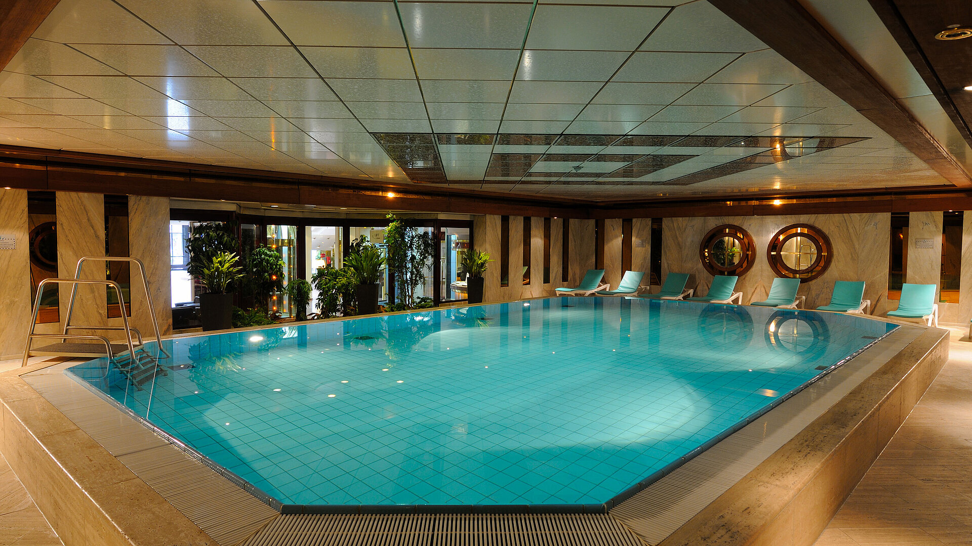 Pool Indoor pool at Maritim Hotel Cologne with loungers and plants for a relaxing atmosphere.