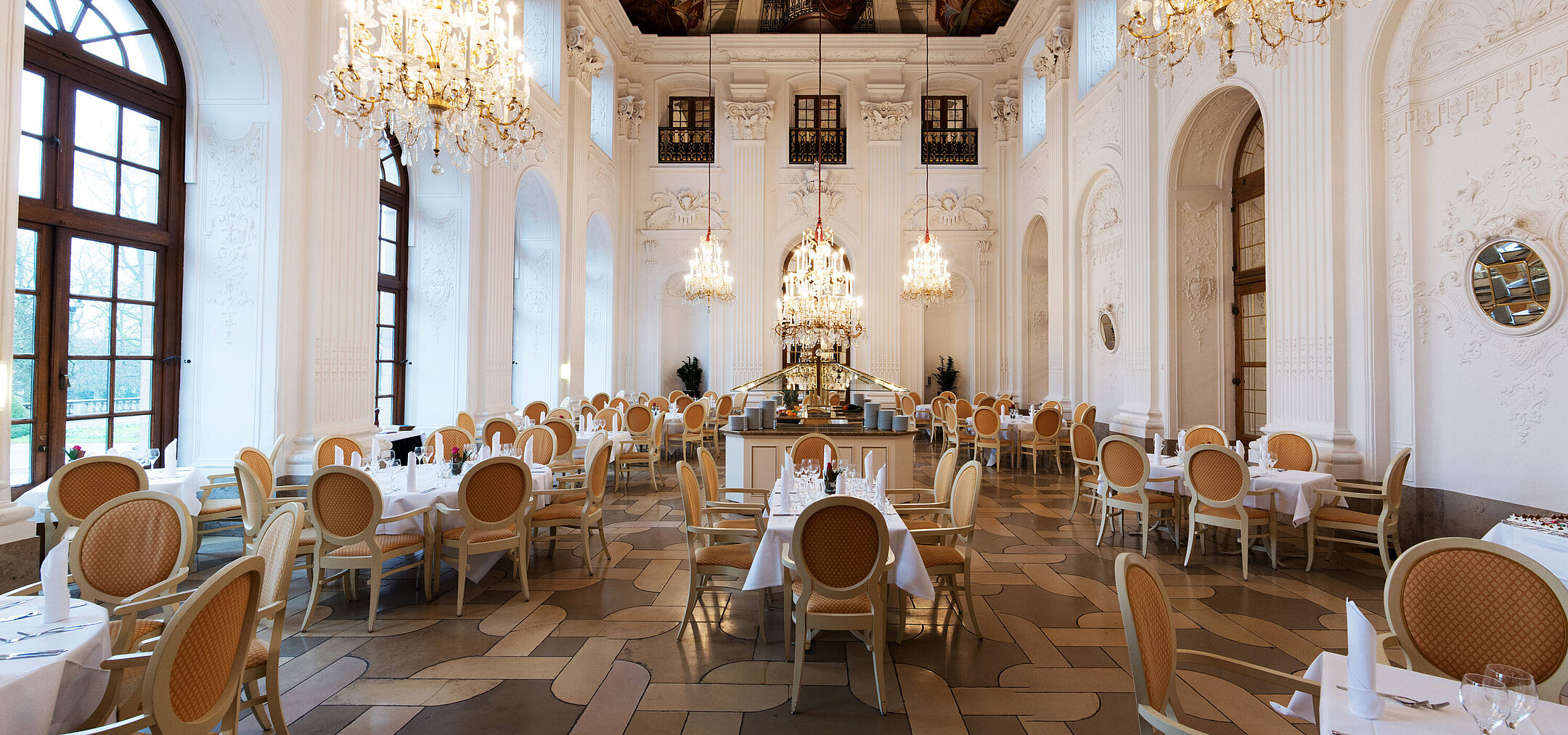 Apollo Saal Restaurant Elegant Apollo Hall at Maritim Hotel Fulda with chandeliers, fresco ceiling, and stylishly set tables.