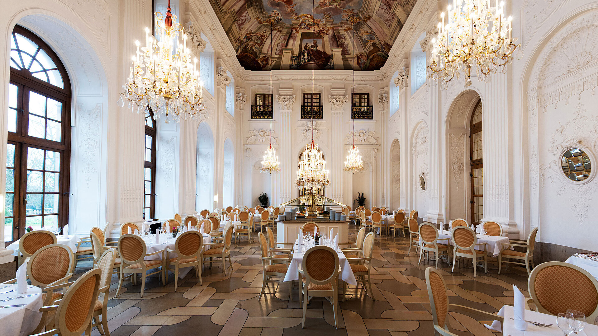 Apollo Saal Restaurant Elegant Apollo Hall at Maritim Hotel Fulda with chandeliers, fresco ceiling, and stylishly set tables.