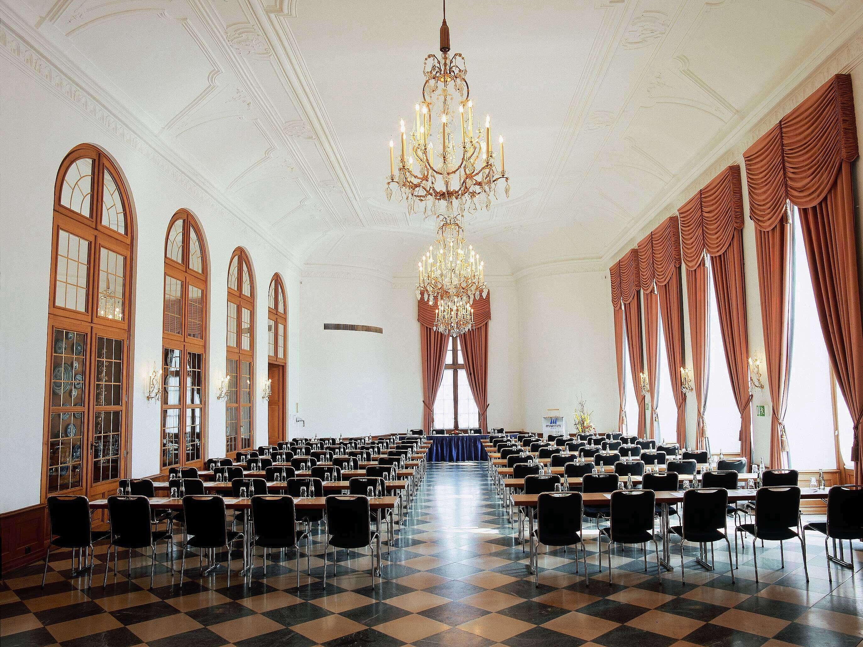 Gelber Saal Elegant event hall at Maritim Hotel Fulda with chandeliers, high windows, and stylish seating for events.