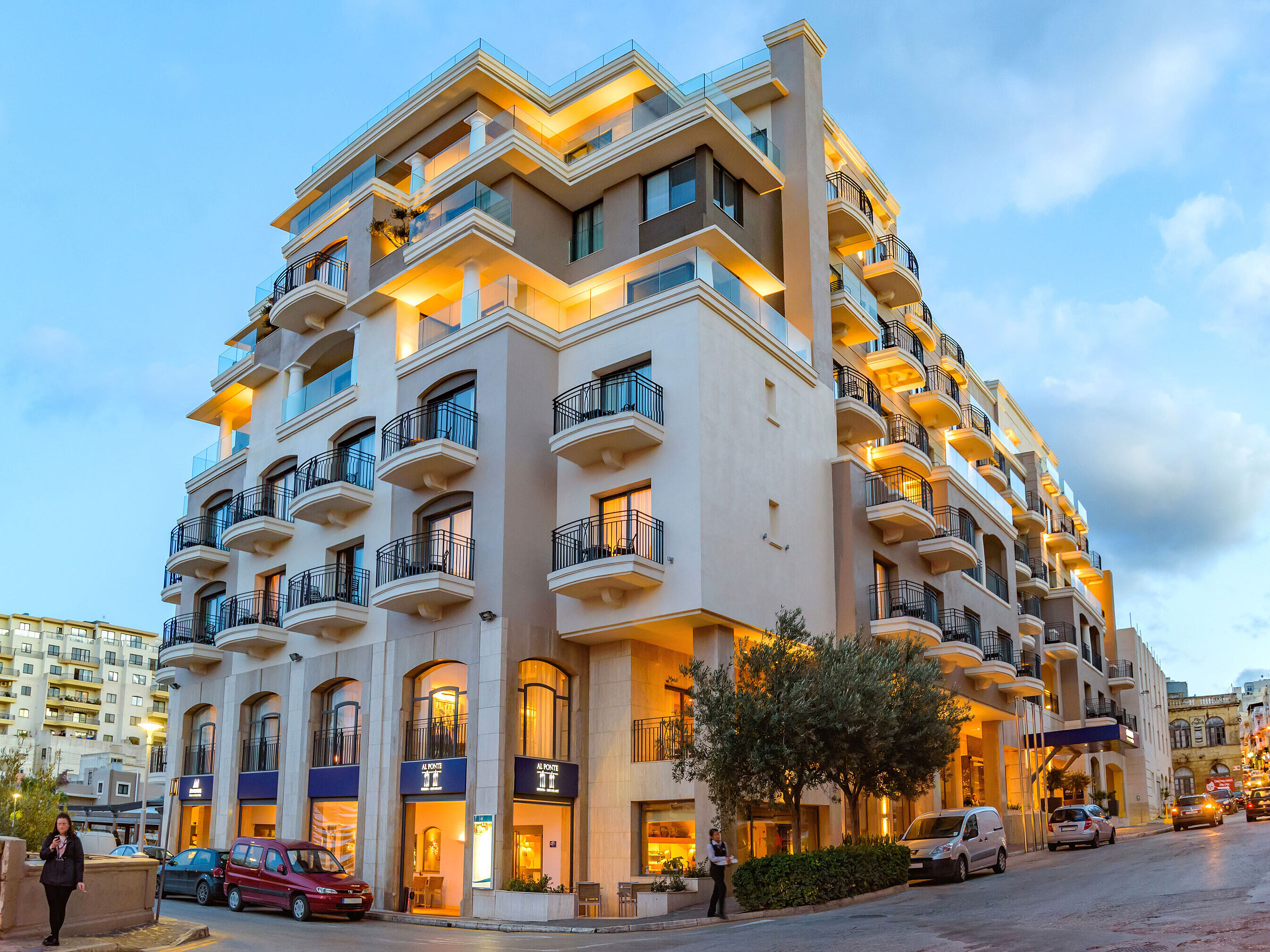 Exterior view Elegant hotel exterior with balconies and warmly lit facade during evening twilight