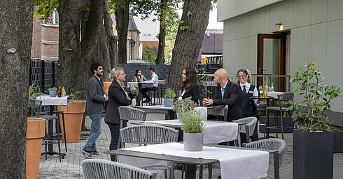 Terrace Saal Maritim Modern terrace at Maritim Hotel Darmstadt with guests relaxing, trees in the background, and stylish gray furniture.