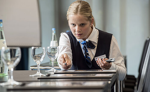 Maritim Conference Service Service staff preparing conference room at Maritim Hotel Bad Homburg with glasses and stationery.