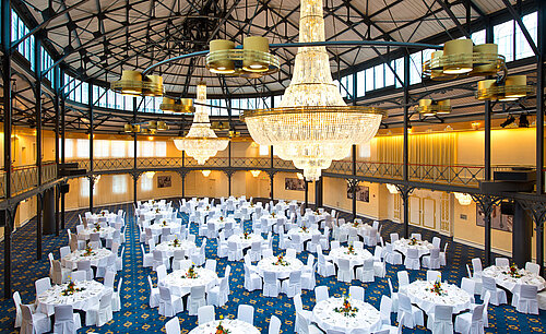 Old Riding Hall Grand banquet hall with round tables and chandeliers at Maritim Hotel Stuttgart