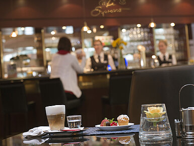 Café Espresso Latte macchiato and pastry at the café in Maritim Hotel Stuttgart with bar view in the background