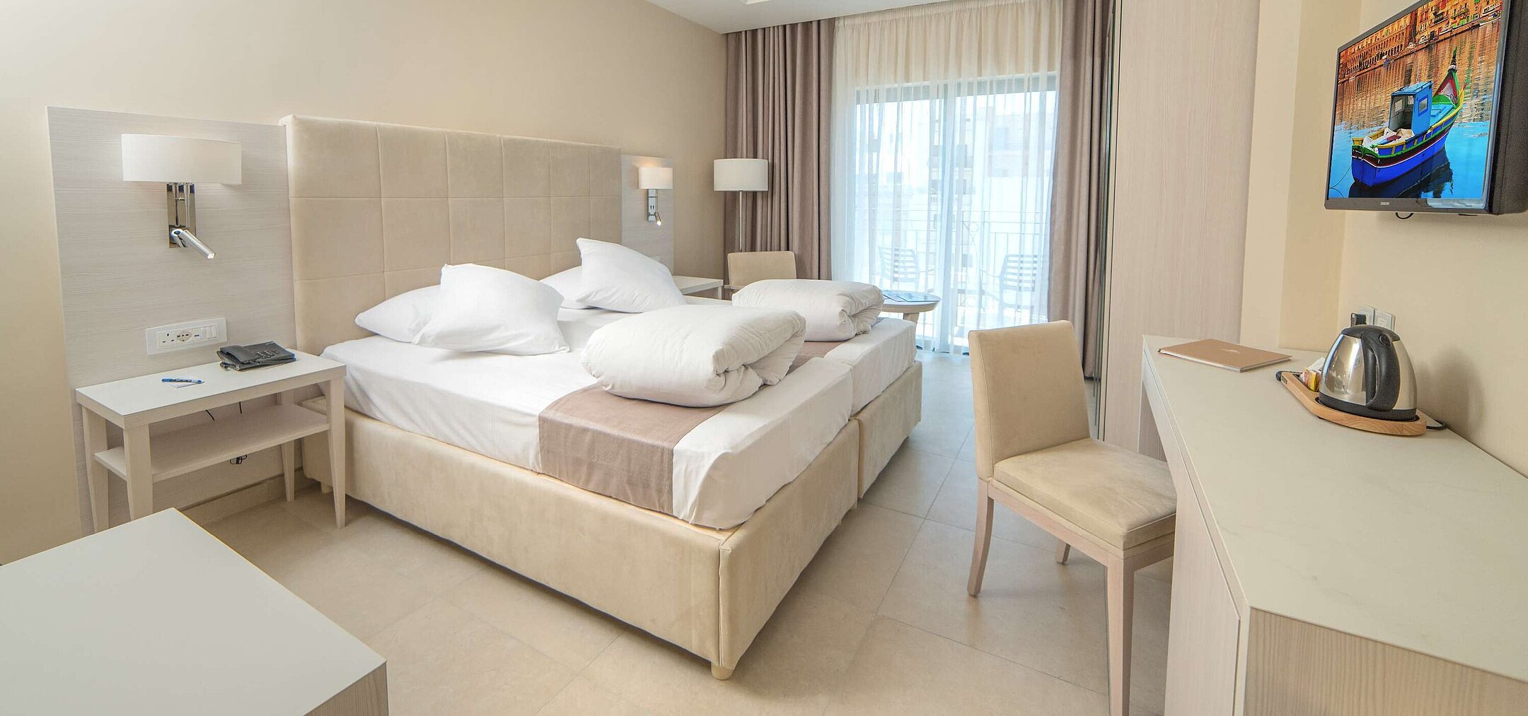 Comfort room Modern double room with comfortable beds, desk, TV and balcony with natural daylight