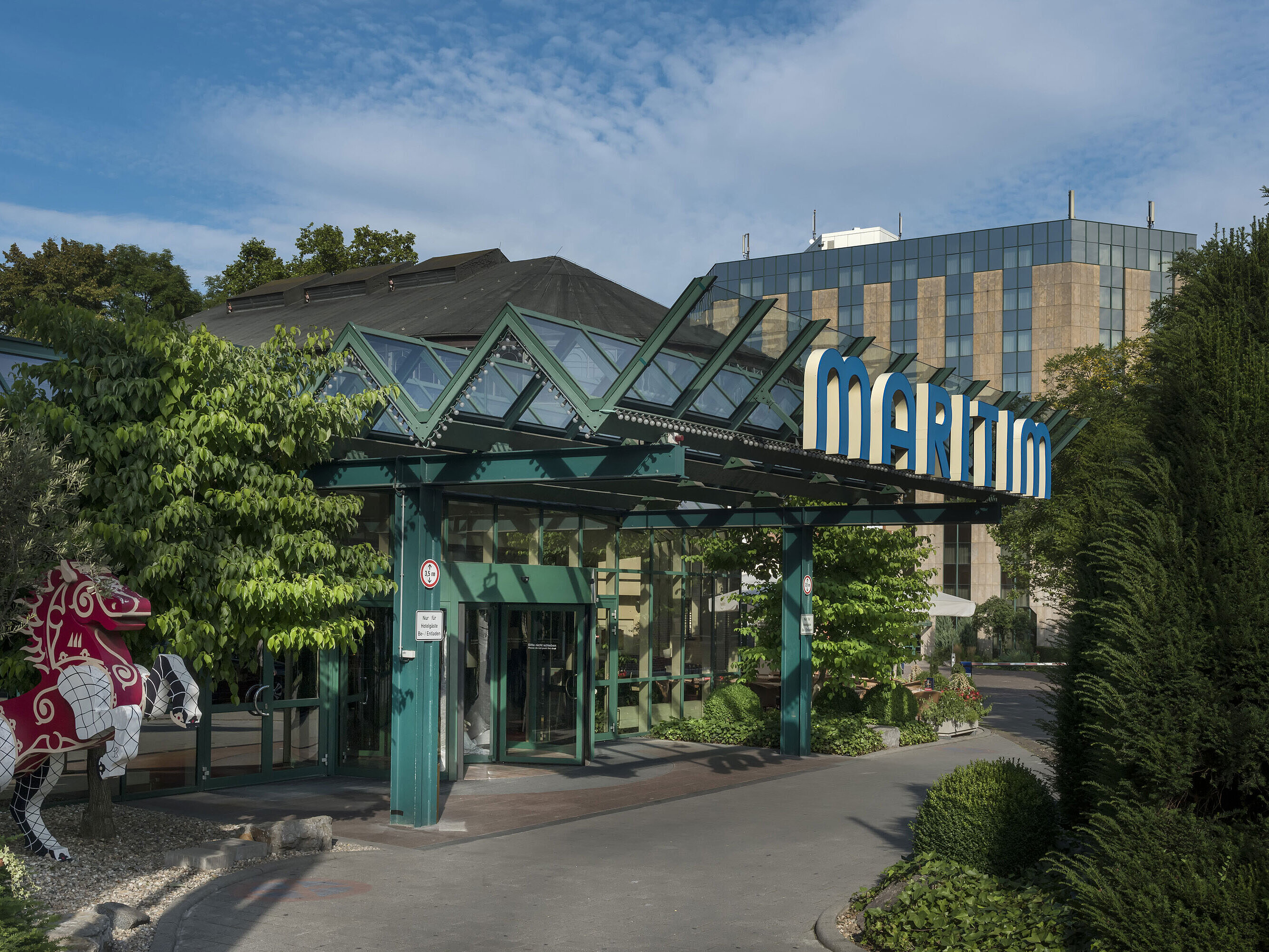 Entrance of the hotel Main entrance of Maritim Hotel Stuttgart with glass roof, green facade and Maritim logo