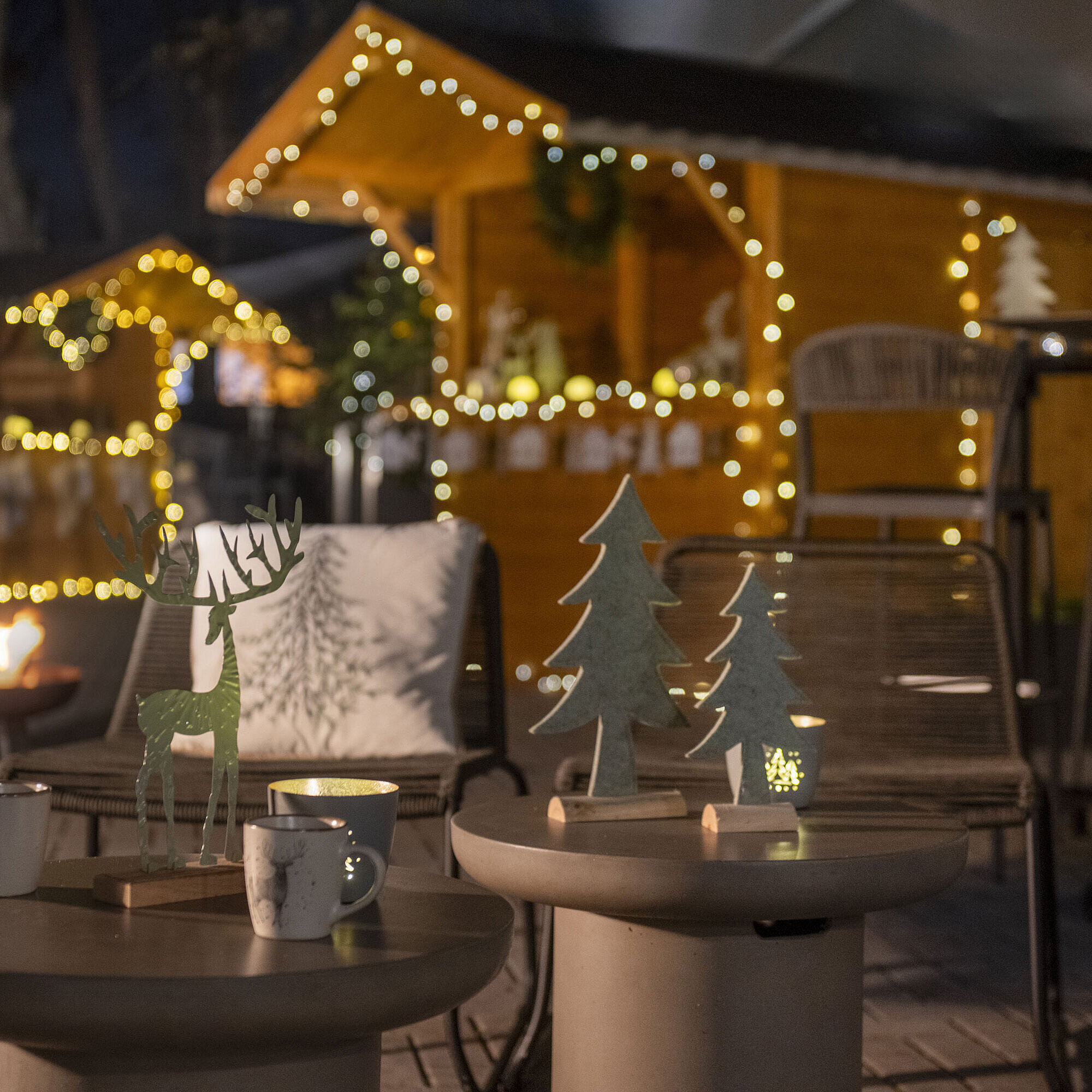 Maritim Christmas Village Festively decorated outdoor area of Maritim Hotel Darmstadt with fairy lights, wooden decorations, and a fire bowl.