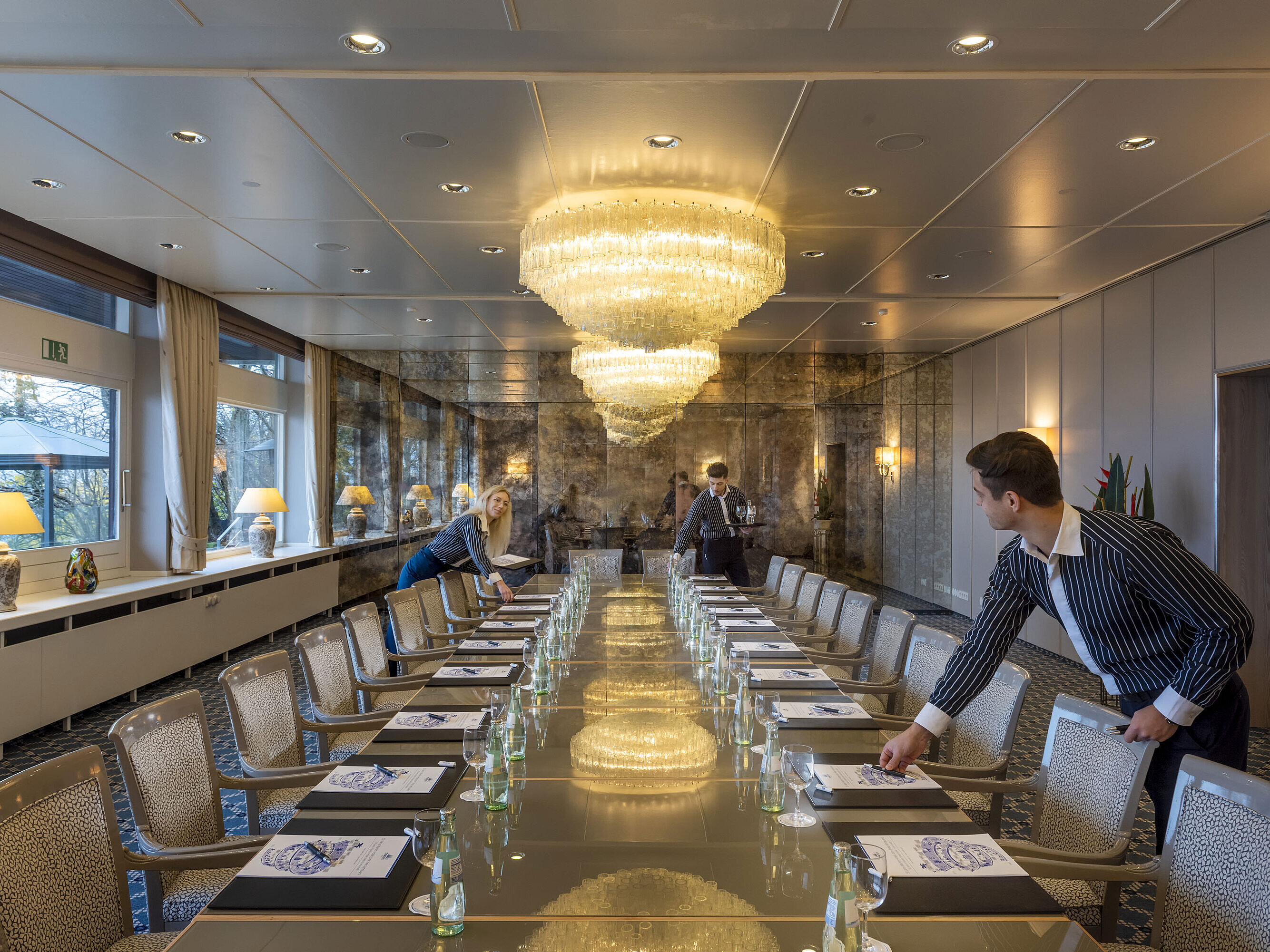 Salon Oslo Salon Oslo in the Maritim Hotel Kiel, elegant conference room with chandeliers and a long row of tables, staff setting up the room.