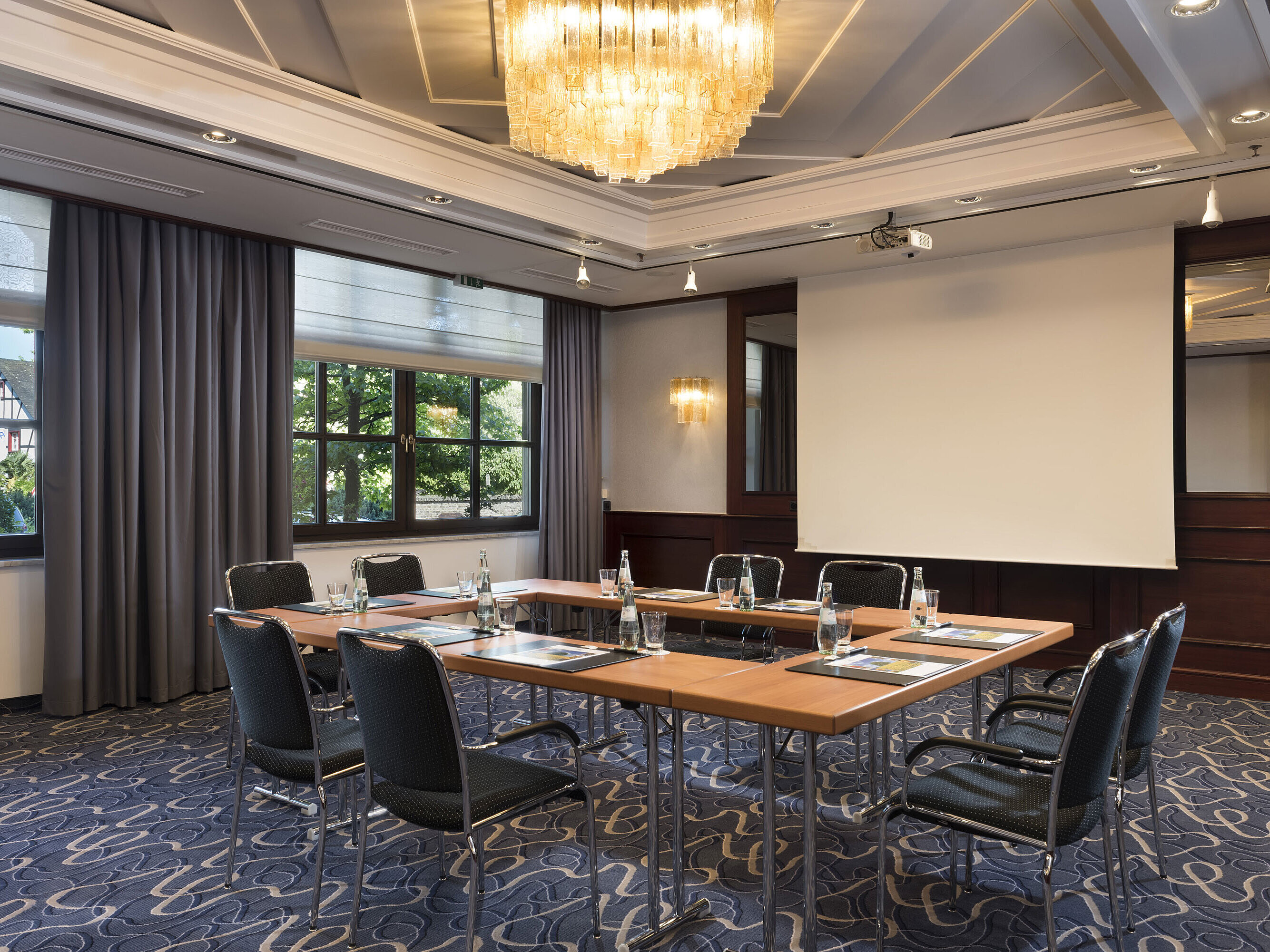 Salon Löwenburg Bright meeting room with modern technology, large windows, and elegant chandelier at Maritim Hotel Königswinter.