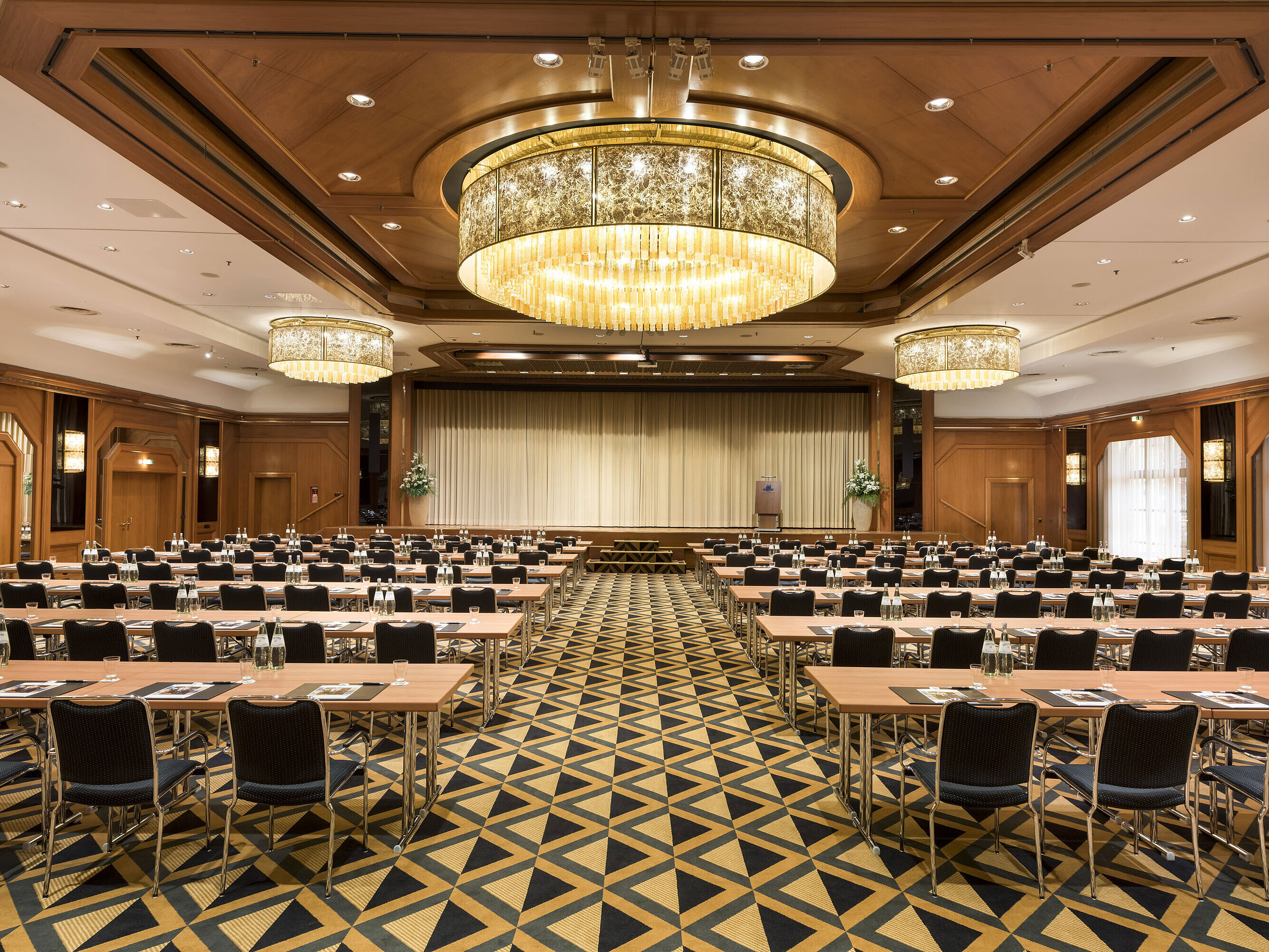 Saal Maritim classroom style Elegant conference hall with stage, chandeliers, and modern seating at Maritim Hotel Königswinter.