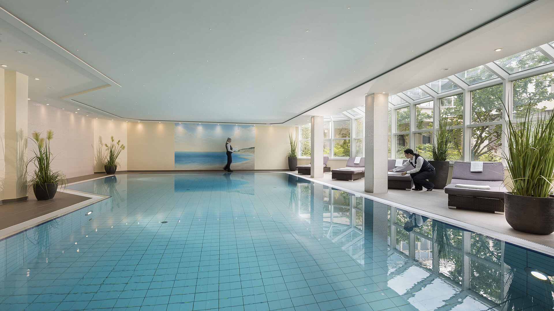 Pool Large indoor pool at Maritim Hotel Würzburg with glass front, loungers and attentive service.