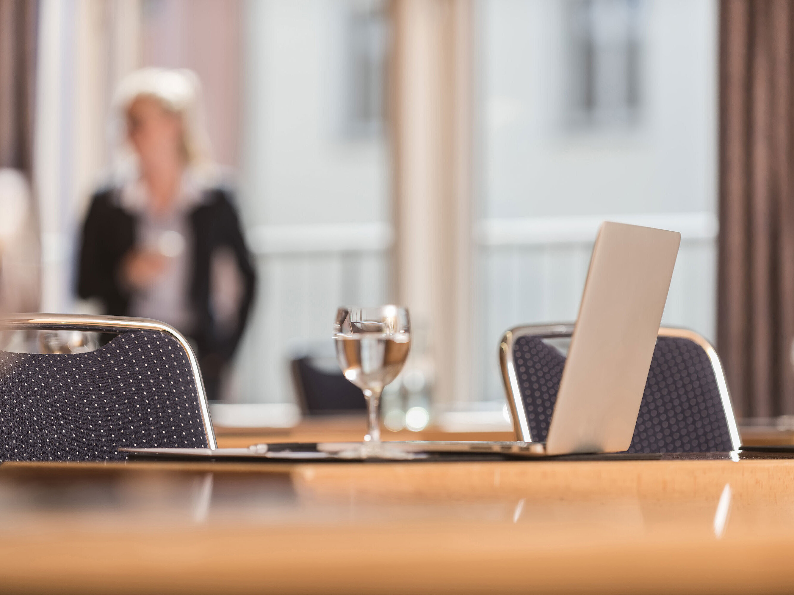 Detailed view meeting room Close-up of a conference room at Maritim proArte Hotel Berlin, focusing on laptop and water glass.