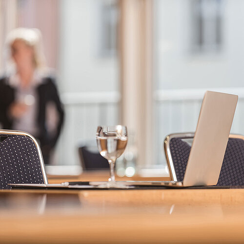 Detailed view meeting room Close-up of a conference room at Maritim proArte Hotel Berlin, focusing on laptop and water glass.