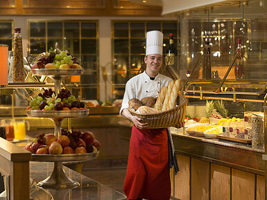 Rôtisserie Restaurant Baker with basket of bread at breakfast buffet at Maritim Hotel Stuttgart, surrounded by fresh fruit