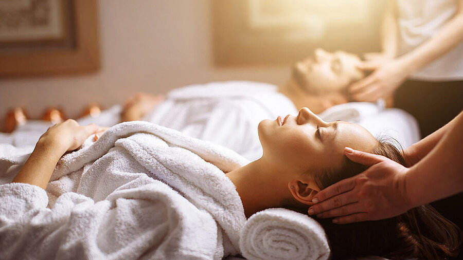 © alfa27 - AdobeStock.com Couple enjoying relaxing head and neck massage at the spa in white bathrobes