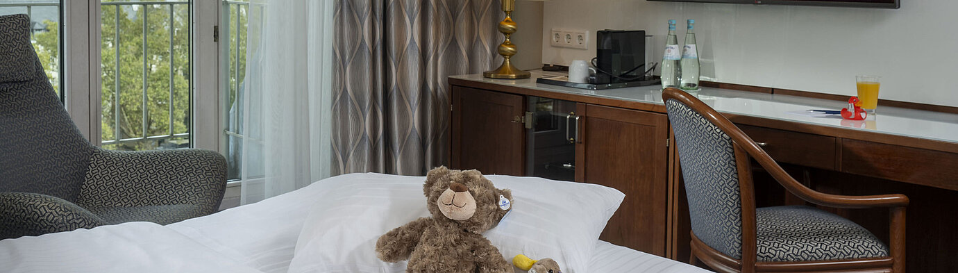 Suite di famiglia Camera familiare presso l'Hotel Maritim Colonia con TV, peluche sul letto e vista sul Reno.