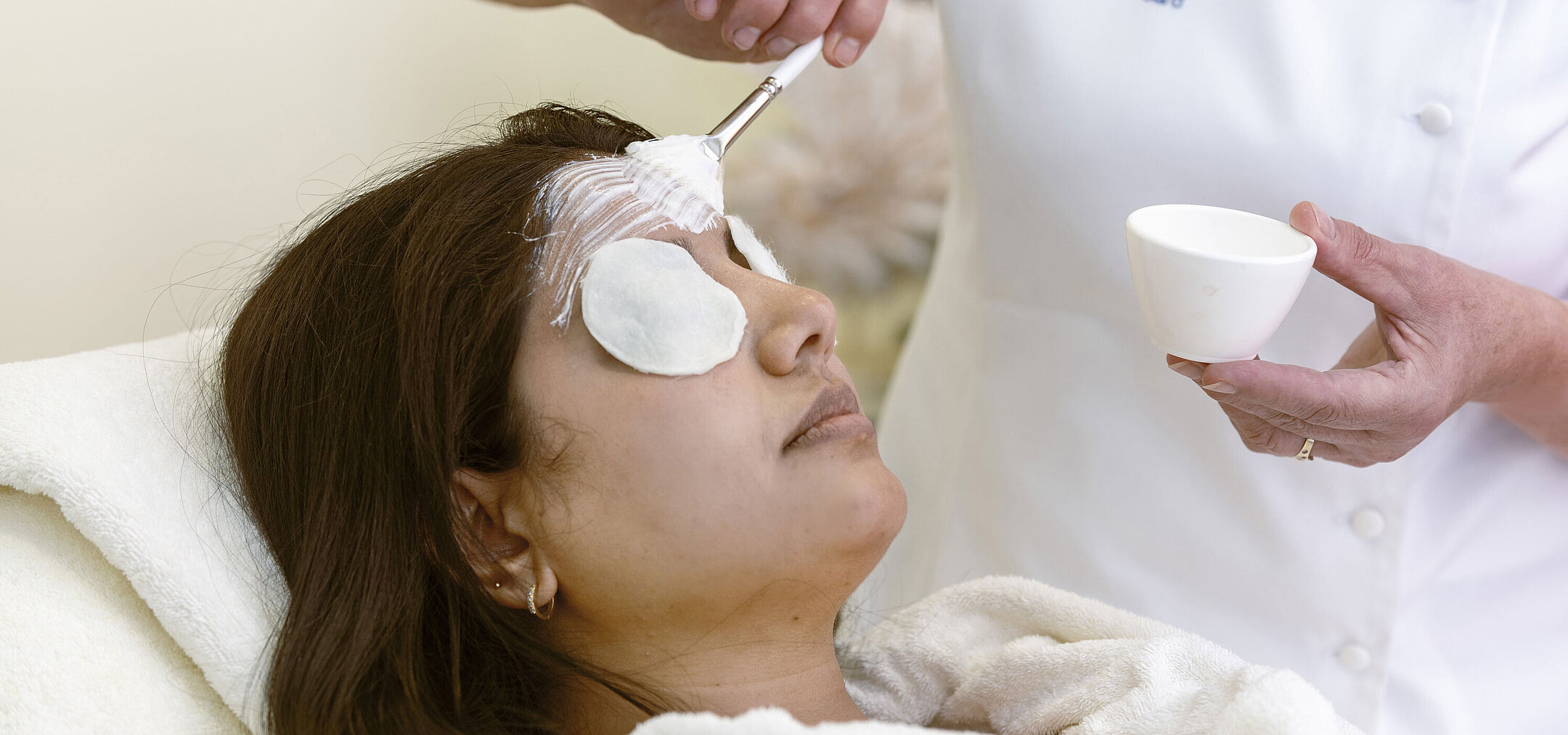 Soin du visage au Spa Soin du visage au Spa de l'hôtel Maritim : une femme reçoit un masque et des soins relaxants avec des cotons.