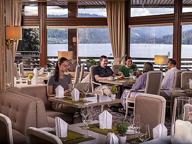 Café Guests enjoying a meal in the elegant restaurant with panoramic view of Lake Titisee