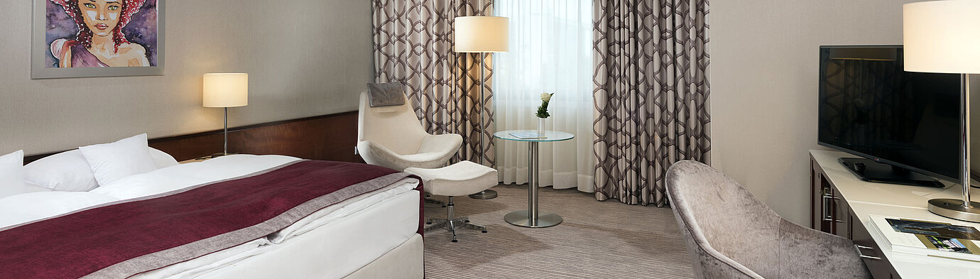 Comfort room Comfort room at Maritim Hotel Bonn with cozy bed, chairs, desk, and modern curtains.
