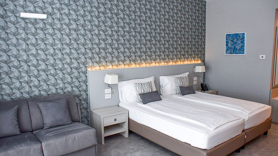 Superior room Spacious room at Maritim Resort Calabria with twin bed, sofa and stylish wall design