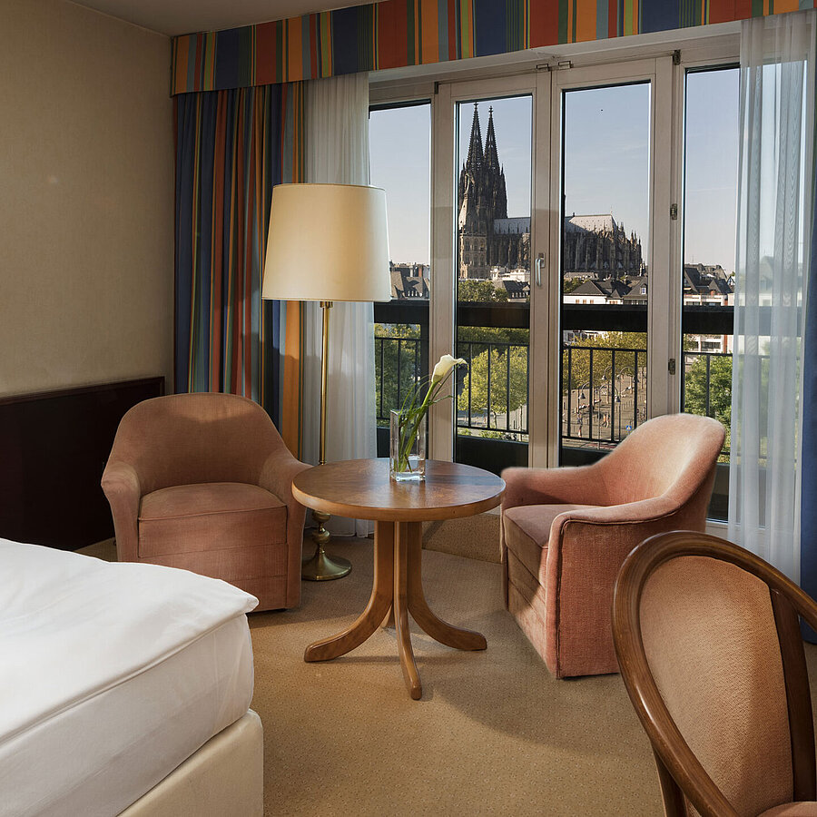 Superior rooms Superior room at Maritim Hotel Cologne featuring a seating area, comfortable bed, and view of Cologne Cathedral.