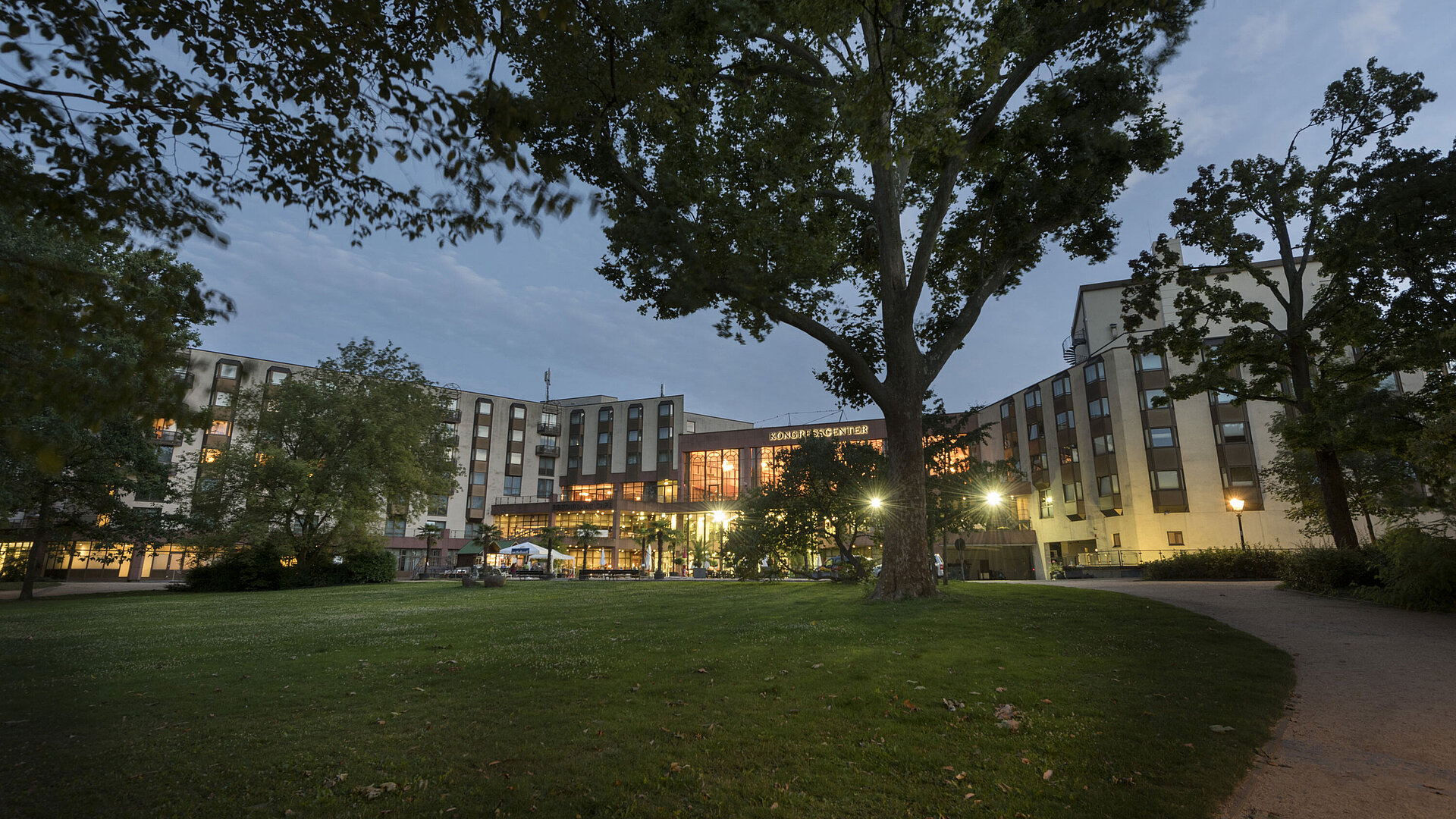 Exterior view congress center View of Maritim Hotel Bad Homburg from the green park at dusk, illuminated congress center.