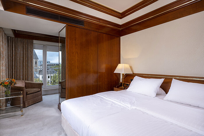 Suite Deluxe Camera luminosa nella suite Heumarkt del Maritim Hotel Colonia con letto matrimoniale, dettagli in legno e accesso al balcone