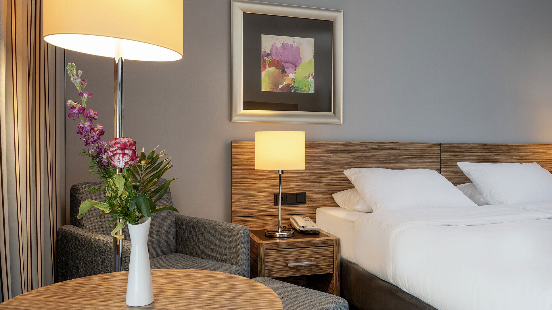Détails de la chambre Coin salon confortable avec vase de fleurs à côté du lit dans la Chambre Superior du Maritim Hotel Darmstadt