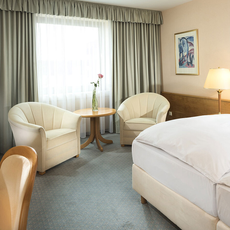 Superior room Bright hotel room with two beds, seating area and large window at Maritim Hotel Magdeburg