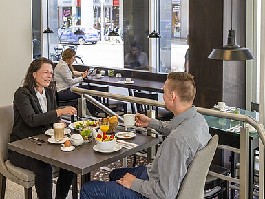 Restaurante Clientes disfrutando de un abundante desayuno en el Maritim Hotel Berlín, rodeados de decoración moderna y grandes ventanales