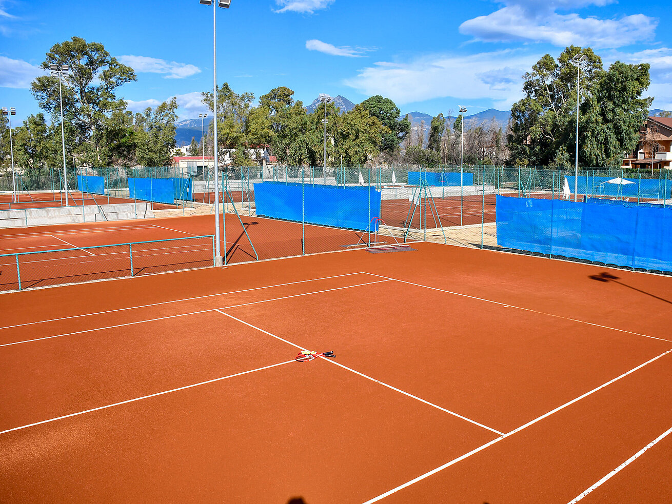 Court de tennis Terrains de tennis en terre battue au Maritim Resort Calabria sous ciel bleu pour activités sportives
