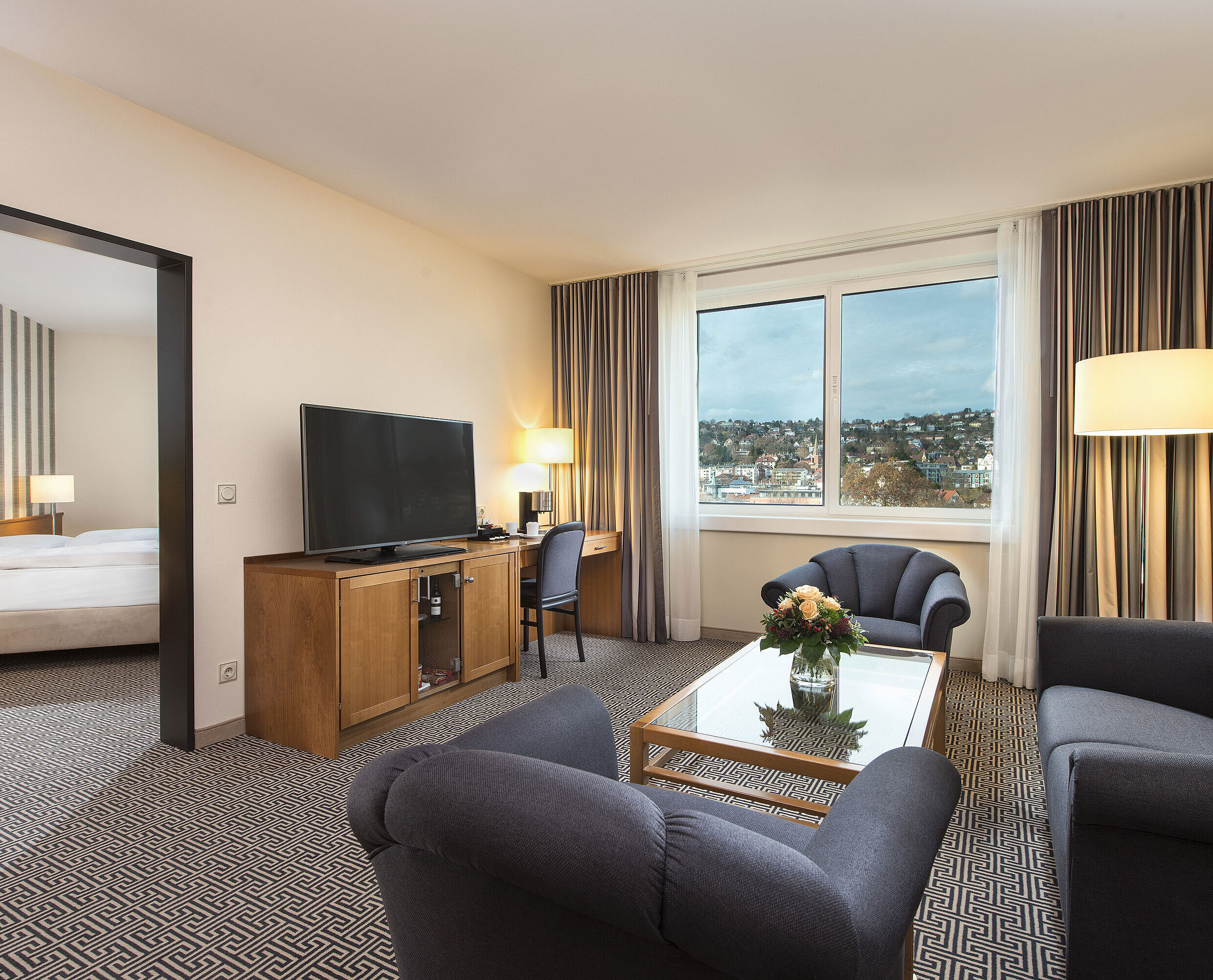 Suite Junior Suite luminosa con vistas, sofás, TV, escritorio y dormitorio