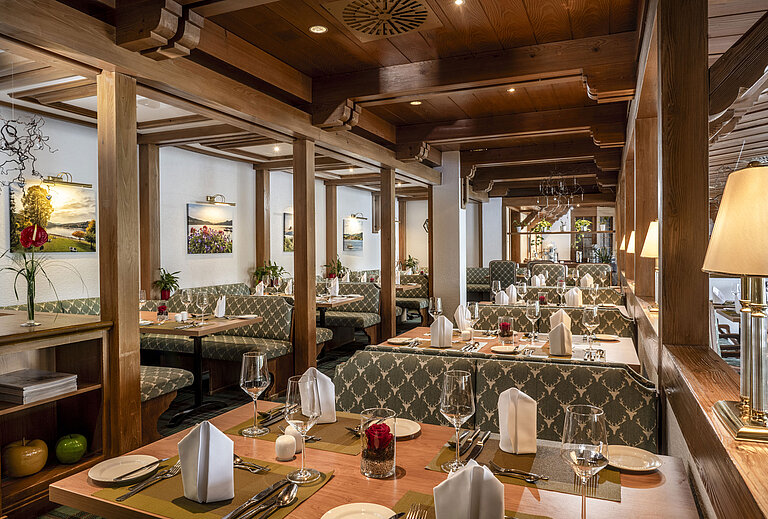 Dinner Cosy restaurant with wooden ceiling and elegantly set tables at Maritim Hotel Titisee