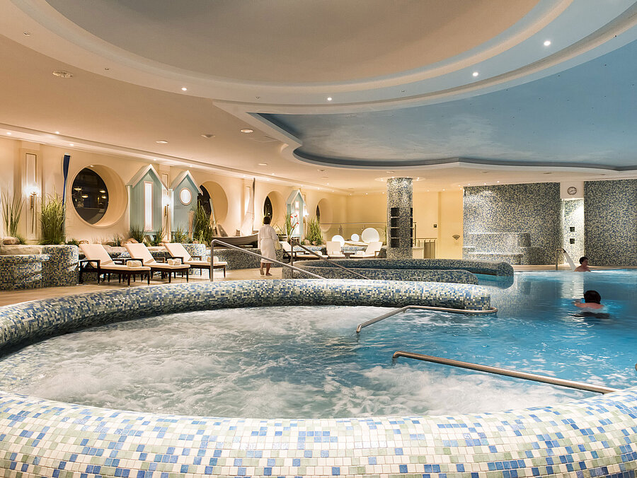 Piscine Grande piscine bien-être avec jacuzzi et chaises longues au Maritim Seehotel Timmendorfer Strand.